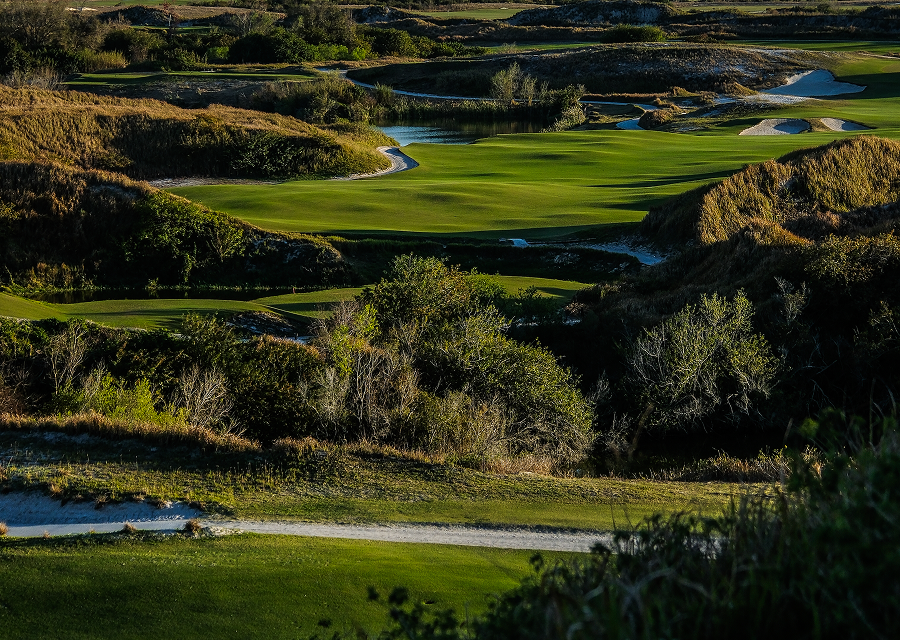 Dramatic view of Streamsong’s rugged golf landscape with deep green fairways winding through sand dunes and marshes.