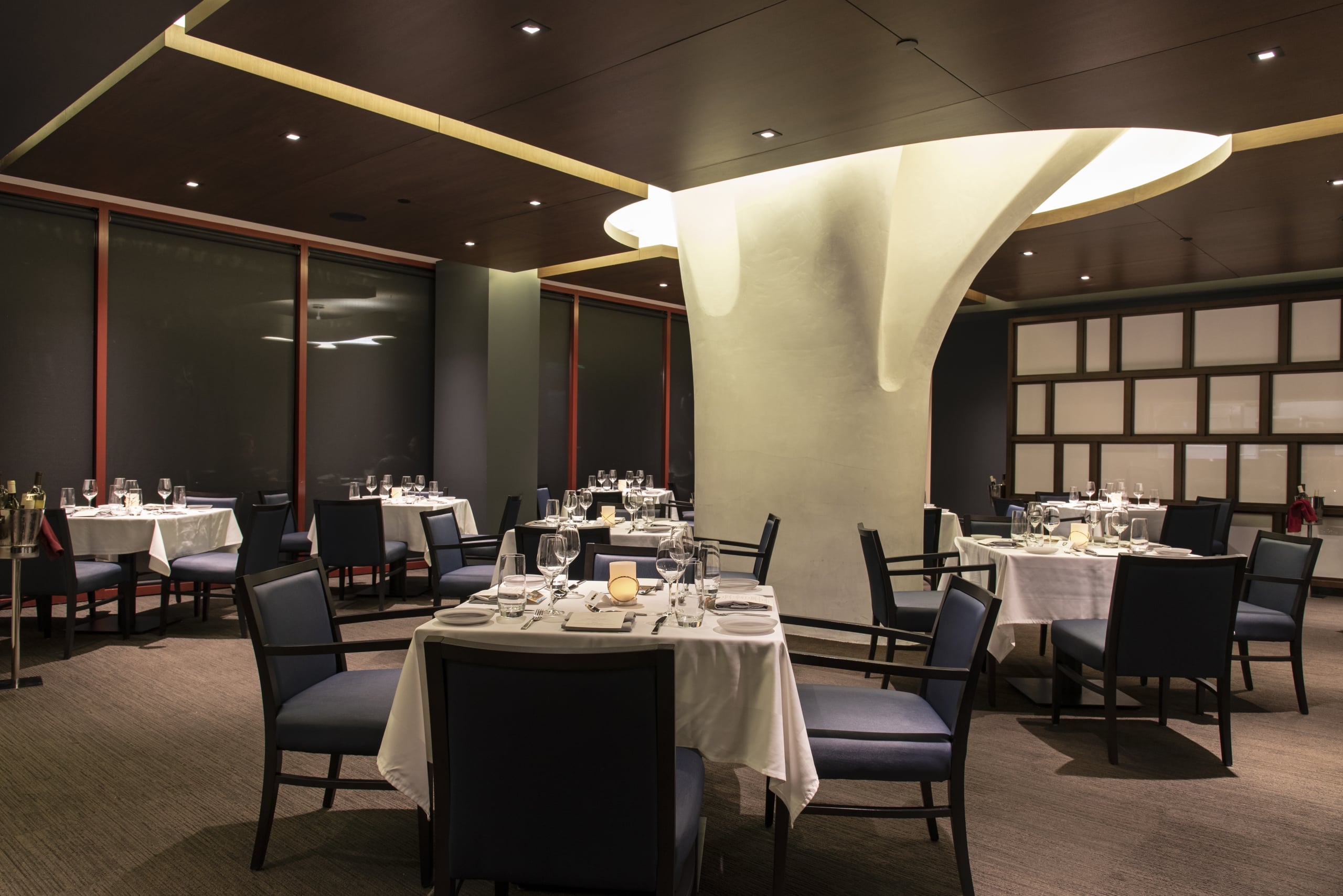 Upscale SottoTerra dining room at Streamsong featuring a large white organic column and elegant table settings.
