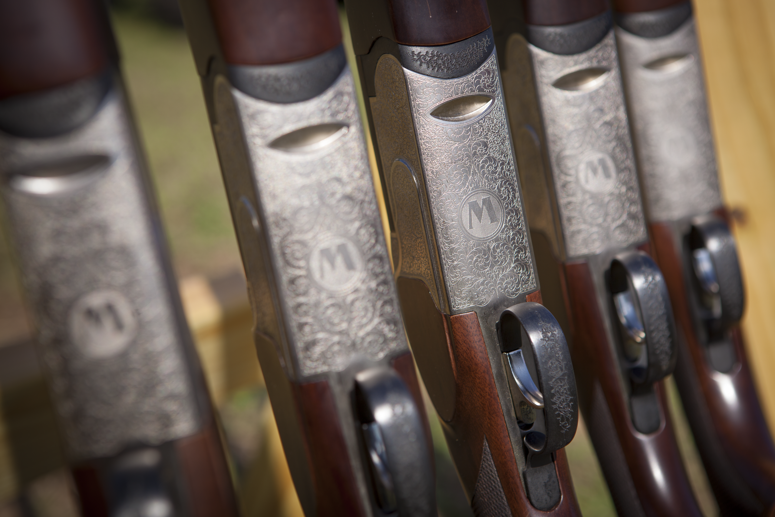 Detailed close-up of several engraved shotguns lined up for a sporting clays session at Streamsong Resort.