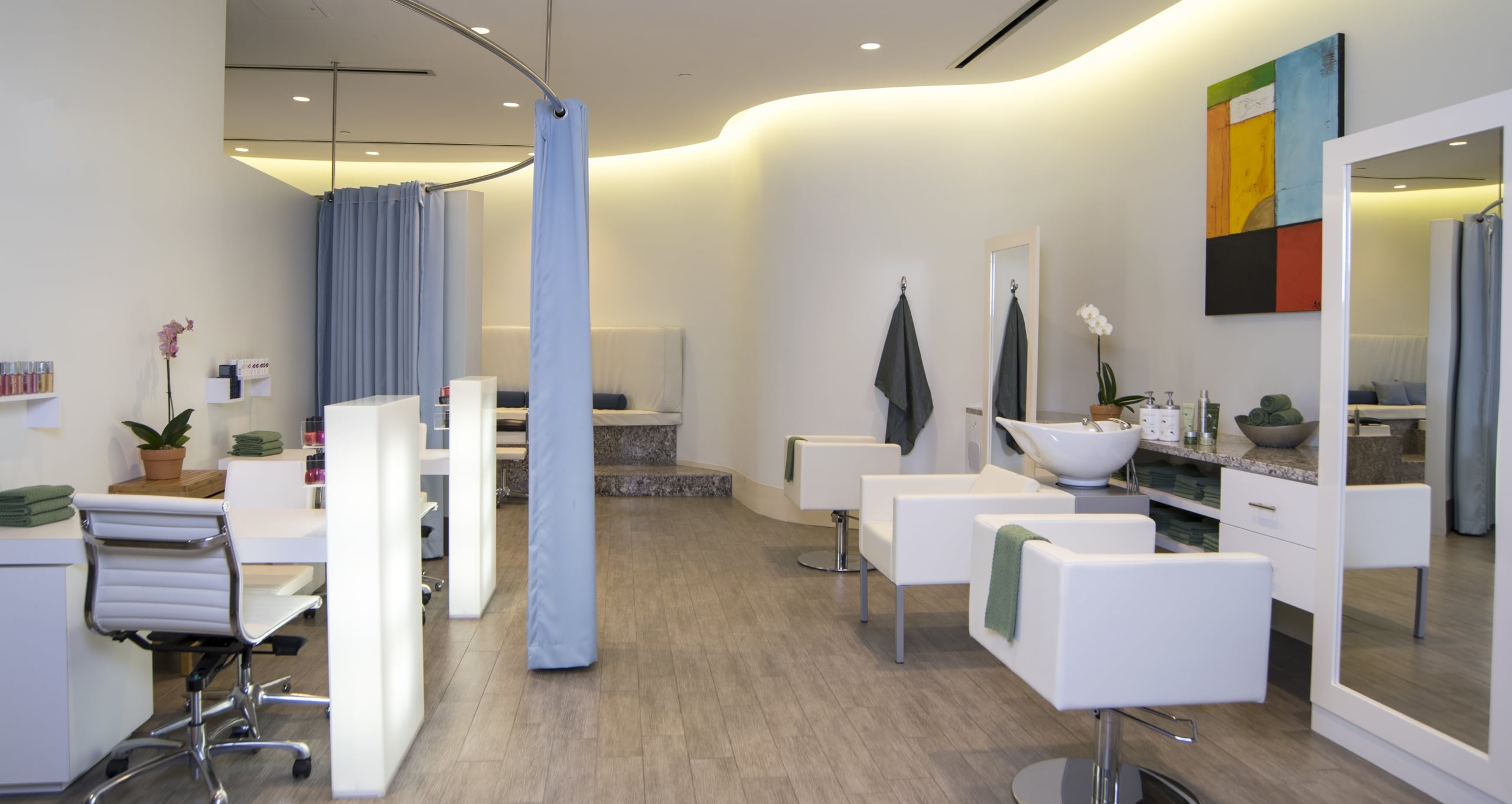 Bright, modern salon at Streamsong Resort with white styling chairs, minimalist decor, and a manicure station.