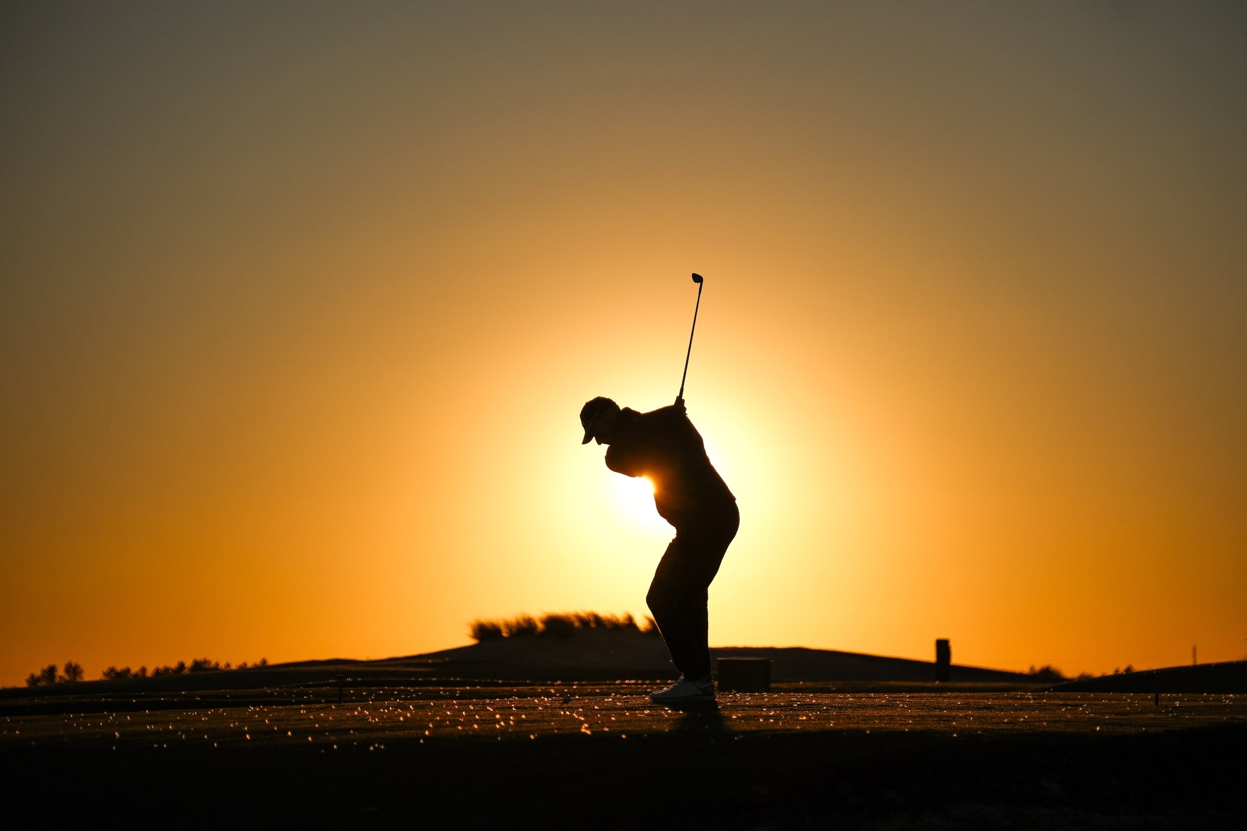 Golfer lines up a shot at dawn