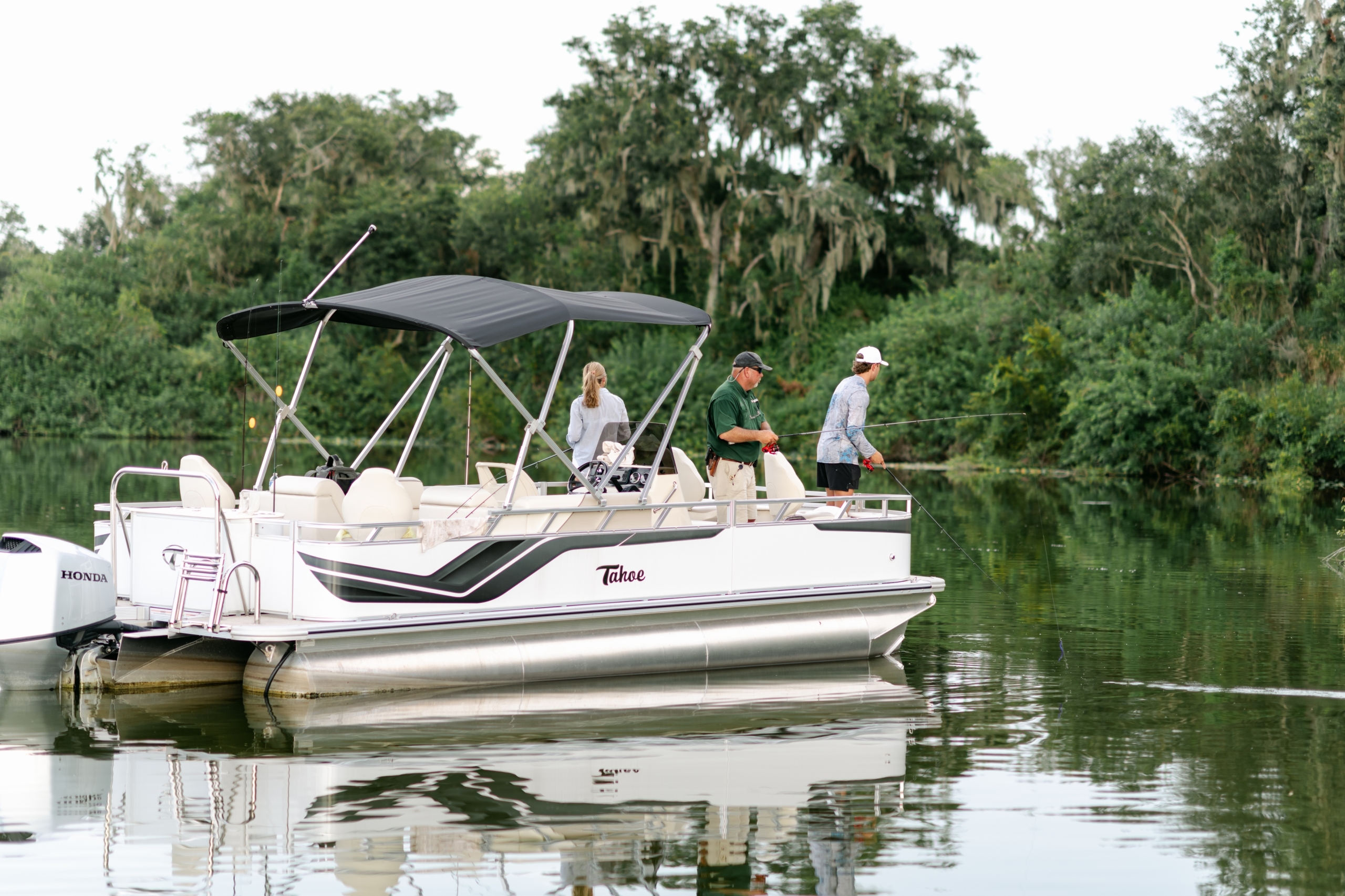 Three people fishing on a boaton a guided fishing tour at Streamsong