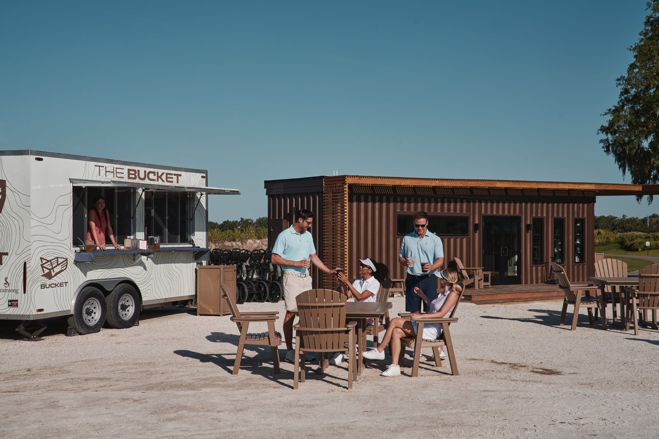 Golfers relax at the Bucket, a food truck and dining area adjacent The Chain golf course at Streamsong Resort